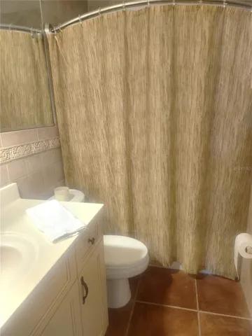 Guest bath with tile throughout and large mirror