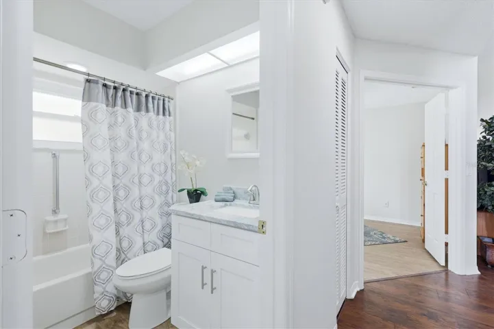 FROM THE SECOND BEDROOM SHOWING THE HALLWAY THE SECOND BATHROOM HAS TALL VANITY AND GRANITE COUNTERTOP