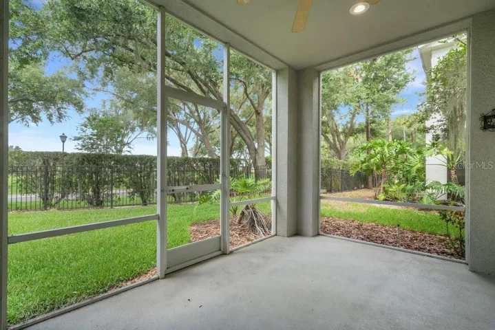 The screen enclosed covered lanai overlooks the greenbelt area behind the building . . .