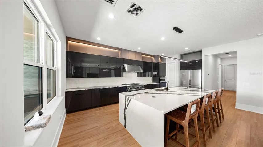 Luxury kitchen with JennAir appliances, quartz counters, and high-gloss cabinetry.