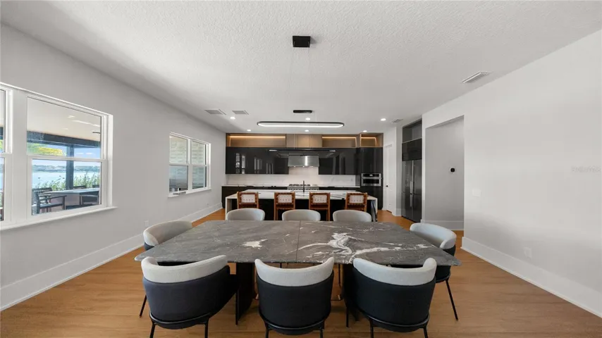 Expansive living and dining area overlooking the covered lanai and waterfront