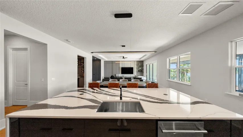 Oversized quartz waterfall island with seating for six and panoramic lake views.