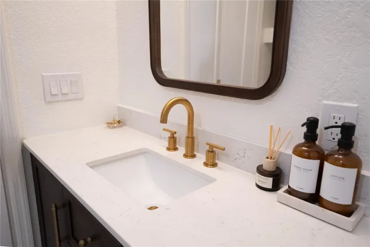 Gold hardware and stone countertop in primary bathroom