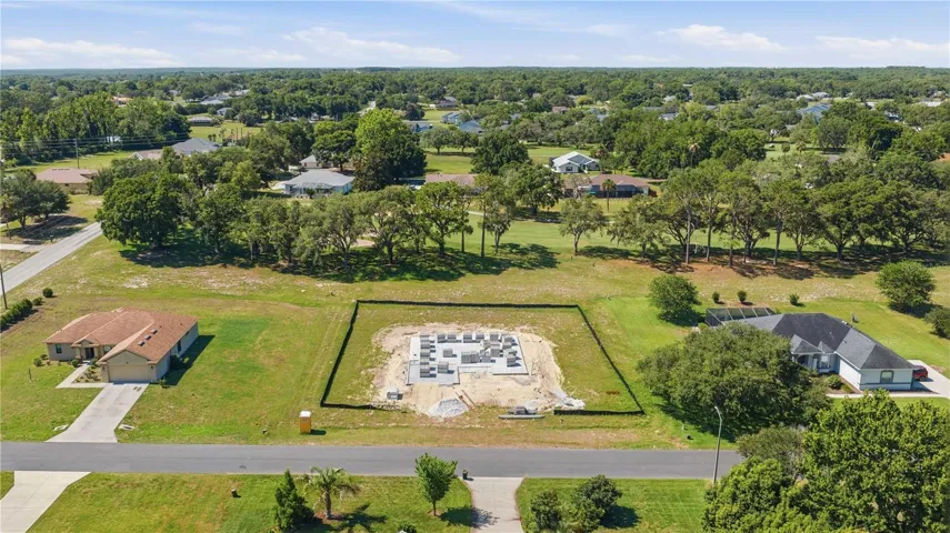 VIEW FROM ROAD WITH GOLF COURSE ADJACENT TO PROPERTY BACKYARD