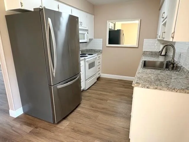 Kitchen, bright and pretty, is convenient to the dining area.