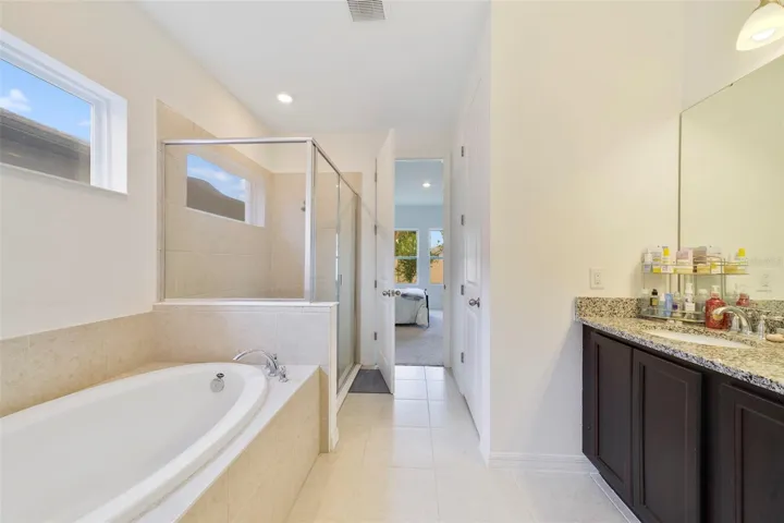 The Primary EN SUITE BATH features dual sinks, a relaxing garden tub, and a separate step-in shower.