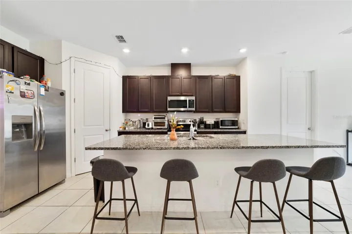 A large center island with breakfast bar seating is perfect for casual meals, hosting friends, or gathering with family.