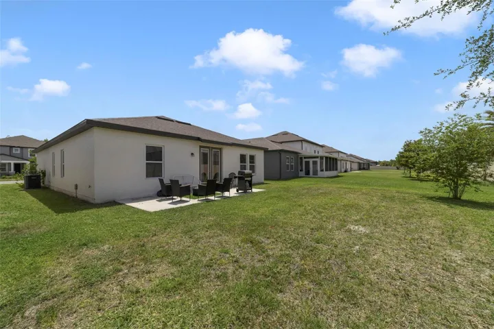 The SPACIOUS BACKYARD offers plenty of room to relax, entertain, garden, or play, while the DECORATIVE BRICK WALL along the rear property line adds both charm and privacy.