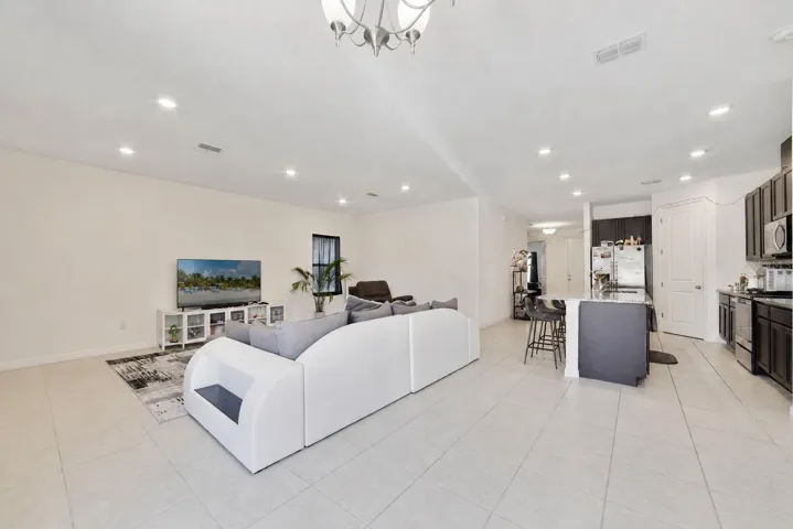 The Living Room, Dining area, and Kitchen flow seamlessly together, all accented by EASY-TO-MAINTAIN CERAMIC TILE FLOORING and ABUNDANT NATURAL LIGHT throughout the main living spaces.