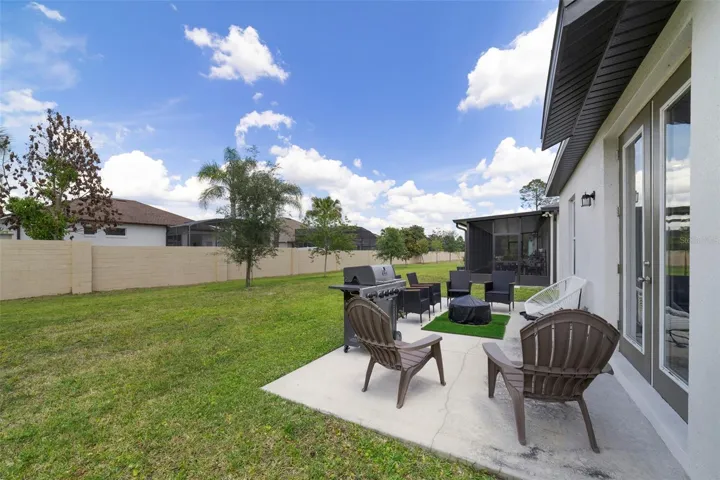 The SPACIOUS BACKYARD offers plenty of room to relax, entertain, garden, or play, while the DECORATIVE BRICK WALL along the rear property line adds both charm and privacy.