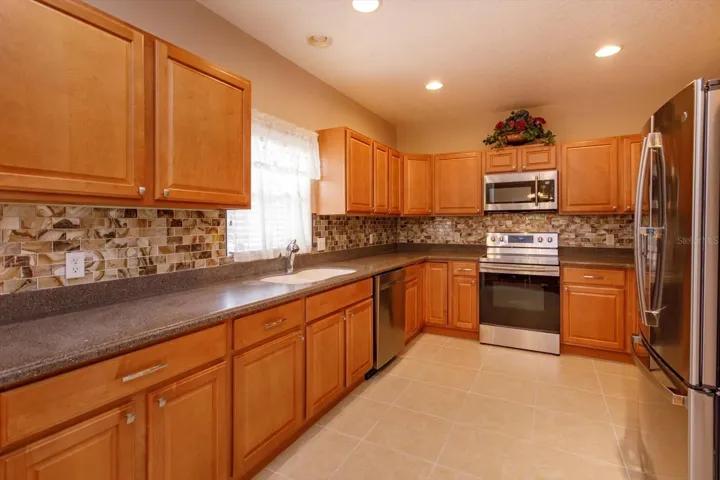 Wood cabinets with glass backsplash