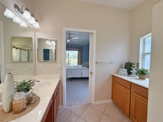 Primary Bathroom with solid wood cabinets, ceramic tile flooring, shower, garden tub, water closet and walk in closet