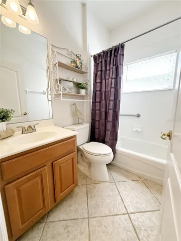 Bathroom 2 with ceramic tile flooring, tub/ shower combo, sold wood cabinets