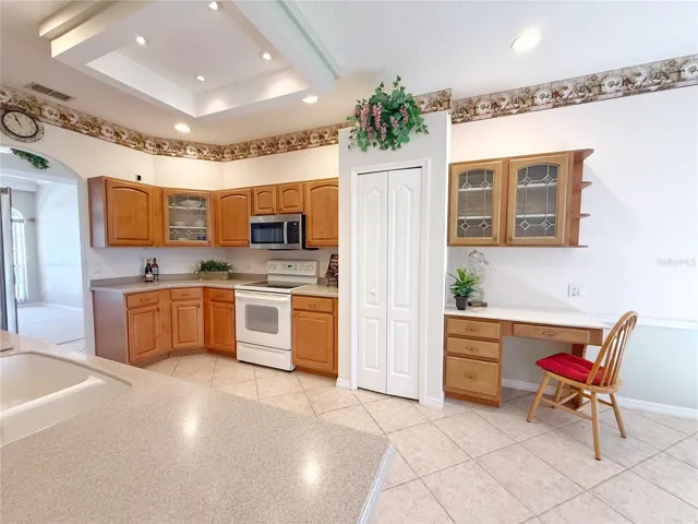 Kitchen with built in desk, ceramic tile flooring, closet pantry, solid wood cabinets, recessed lighting, under cabinet lighting