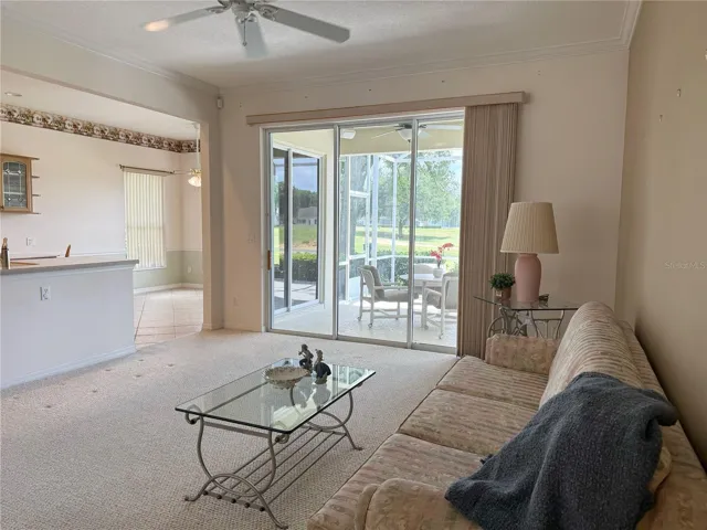 Living room with view of stackable sliding glass doors and Kitchen dinette in background
