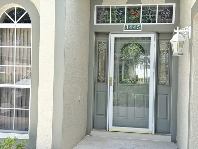Front entry with storm door and beveled glass front doors