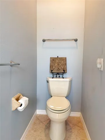Primary water closet with ceramic tile flooring