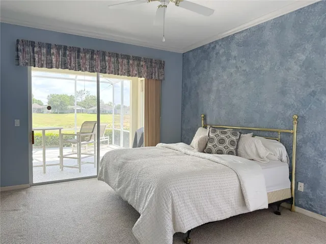 View out of Primary sliders of lanai and Golf Course, crown molding, en suite bathroom, walk in closet