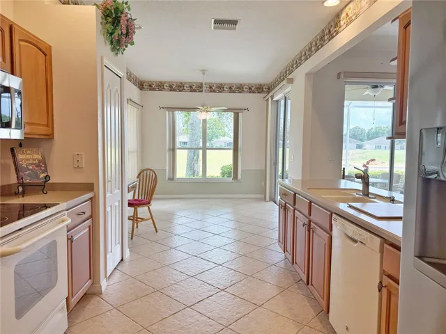 Kitchen with eat in area, solid wood cabinets, recessed can lighting, ceramic tile flooring, built in desk