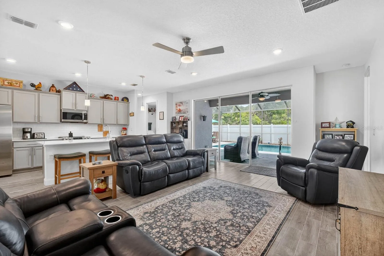 Open floor plan features triple sliding doors out to the gorgeous backyard saltwater pool