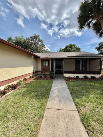 Sidewalk to entry with covered screened in large patio