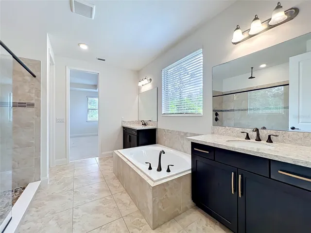 The elegant owner’s bath offers a spa-like experience with quartz countertops