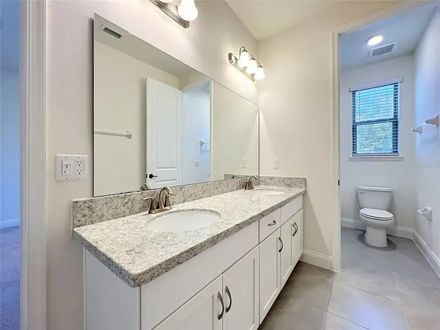 Jack-and-Jill bathroom featuring quartz countertops