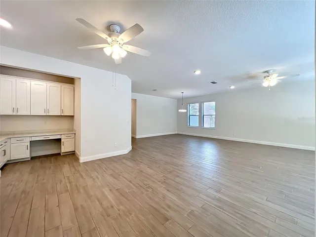 Functional home office area featuring custom built-ins, ample cabinetry, and decorative crown molding