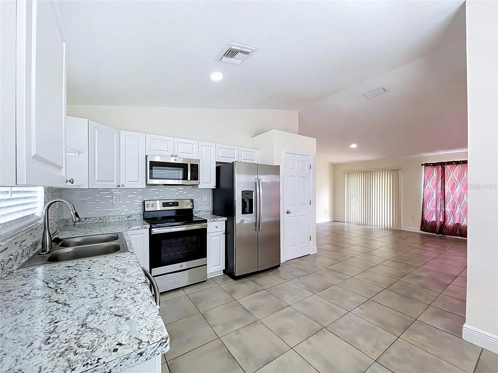 Kitchen View to Living Room with Doors to Outside