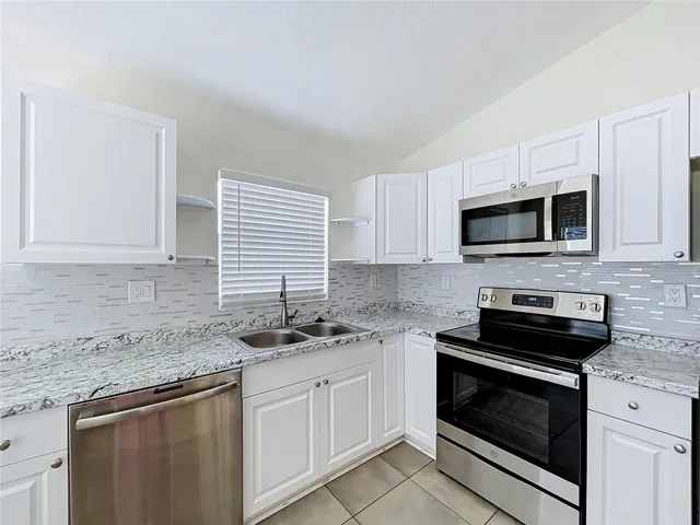 Kitchen View Stainless Steel Double Sink Under Window with Dishwahser and Microwave with Stove andSpacious Cabinets