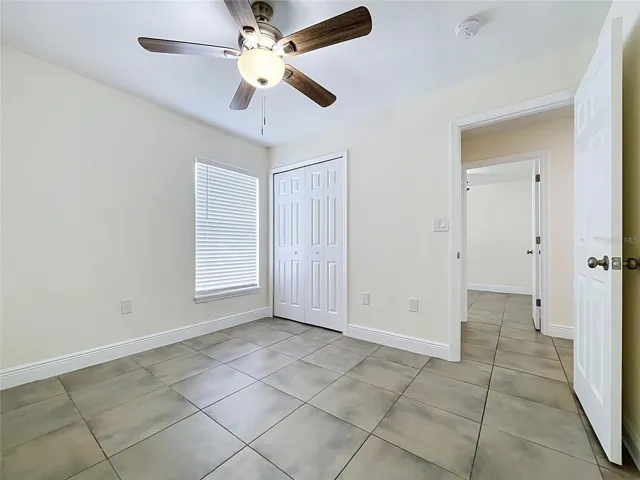 Bedroom with Fan,Ceramic Floor and Oversized Window and Closet