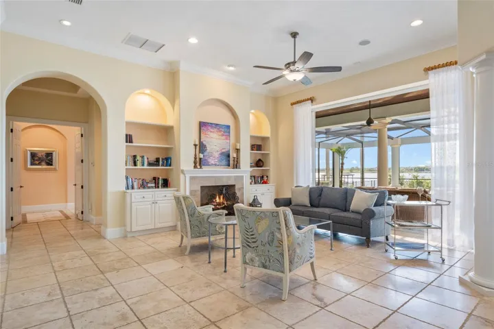 Living Room with lake view and fireplace and travertine flooring.
