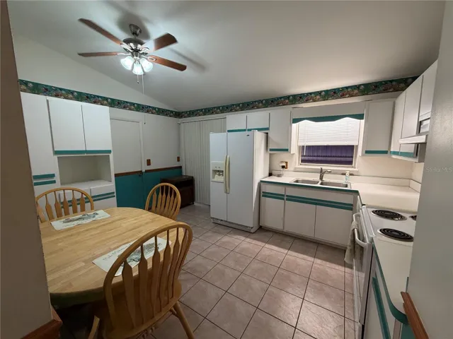 Kitchen with Tile Flooring, Sliders to Exterior, Exit to Garage, Ceiling Fan, Vaulted Ceiling