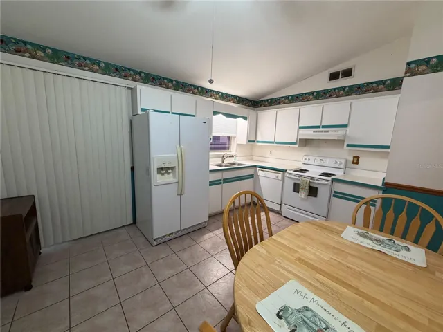 Kitchen with Tile Flooring, Sliders to Exterior, Exit to Garage, Ceiling Fan, Vaulted Ceiling