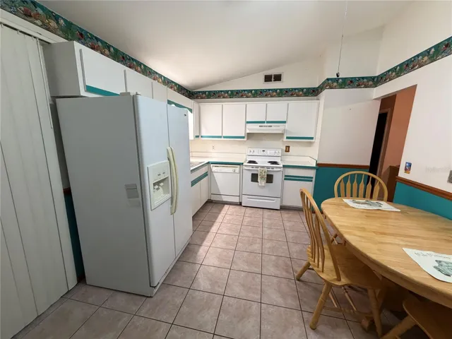 Kitchen with Tile Flooring, Sliders to Exterior, Exit to Garage, Ceiling Fan, Vaulted Ceiling