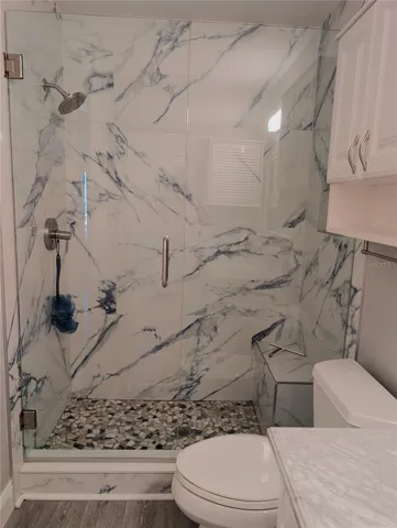 Totally renovated guest bathroom features gorgeous shower with bench, glass shower door and grab bars as well as new comfort height commode.