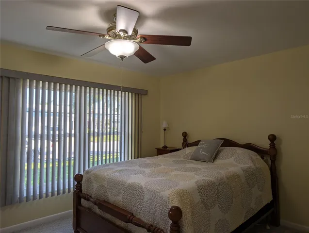 Guest bedroom features include vertical blinds for large window, new carpeting, new ceiling fan and a walk-in closet.
