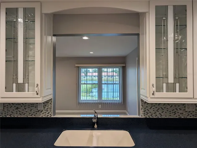 Kitchen pass thru window is framed by two stunning leaded/stained glass cabinet doors. A simply beautiful design and focal point. Beautiful view from kitchen to backyard to enjoy while working in the kitchen.