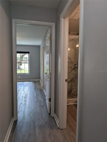 Hallway view into primary bedroom ensuite and guest bathroom on right.