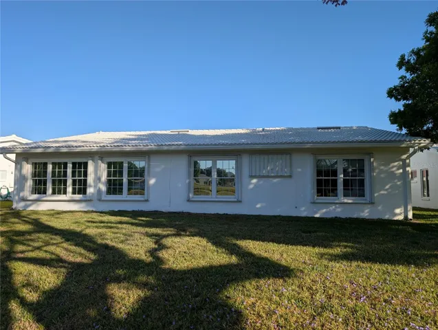 Exterior view of back of the home.  Accordion storm shutters to protect during storm season. Updated tile roof 2020.