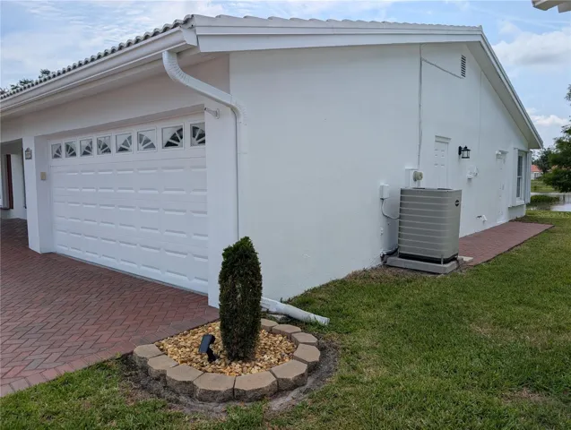 Exterior side view. Updated side garage man-door w/new exterior light has direct access to side yard.