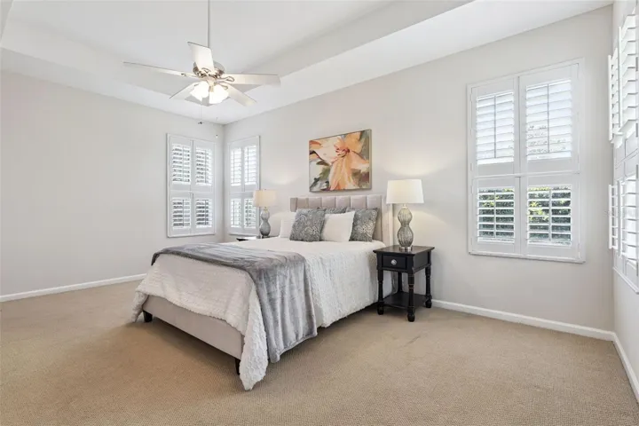 Primary Bedroom w/ multiple windows overlooking the private backyard