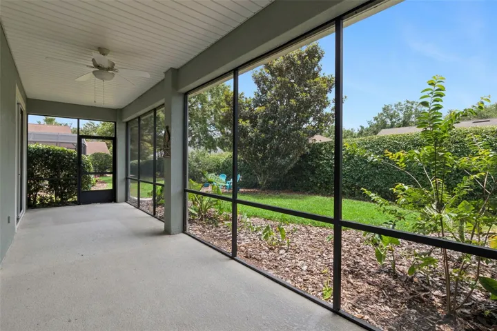 30' x 8' Screen enclosed covered patio w/ a ceiling fan overlooking a private backyard