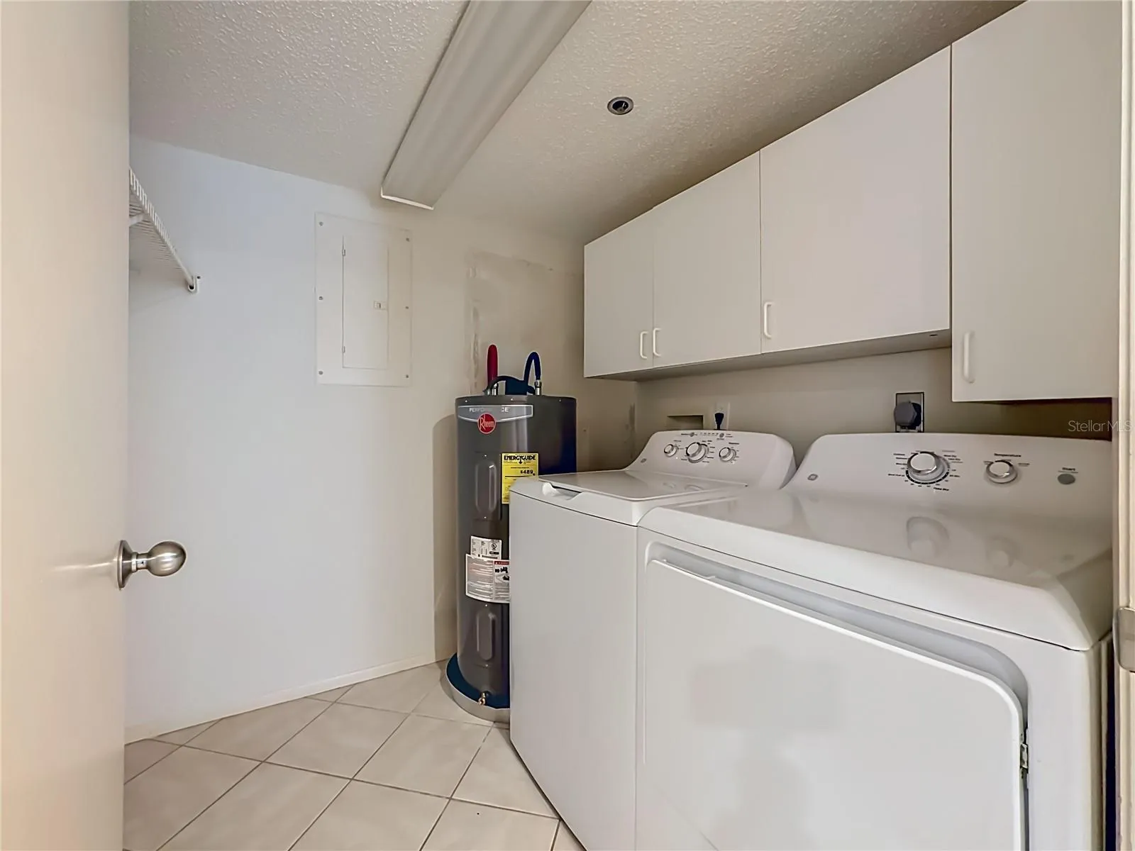 Laundry room with full size washer and dryer and additional cabinets for storage.