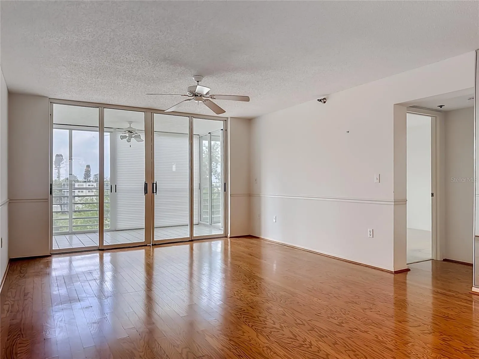 Living room with sliding door to the larger glass enclosed lanai/Florida room.