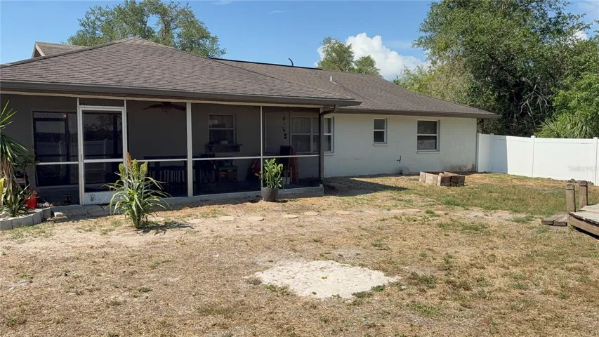 VIEW FROM LEFT BACK CORNER OF BACK YARD TO BACK OF HOME