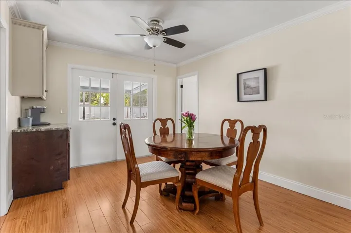 Dining Room with coffee bar cabinet/storage.  French Doors lead to the porch.  Door to the right leads to the Primary bedroom.