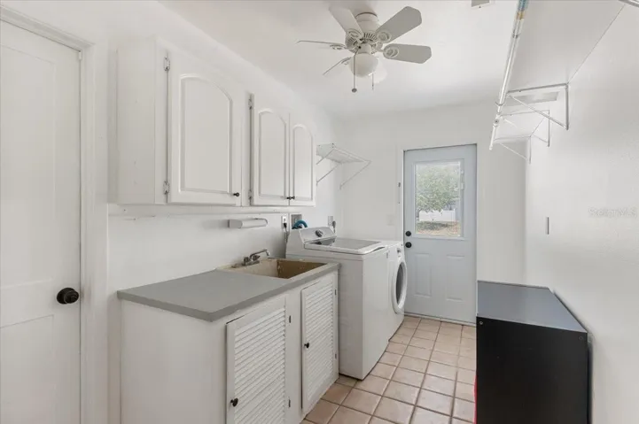 Indoor Laundry room.  Door on left leads to the 2 car garage.  Door with the window leads to the driveway.