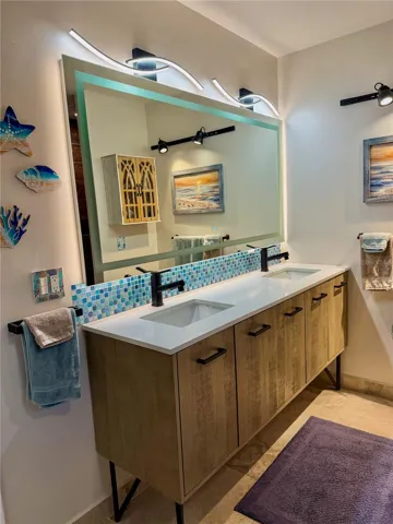 Master bath with double sinks and light-up mirror