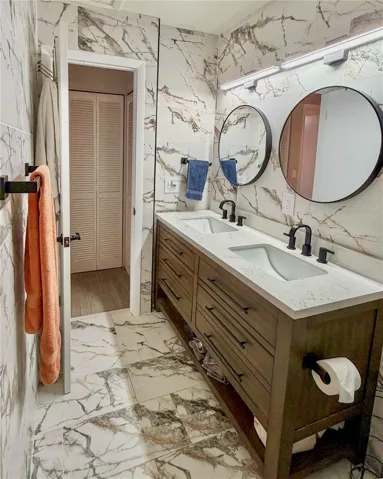 2nd floor bathroom with double sinks and floor to ceiling tiles